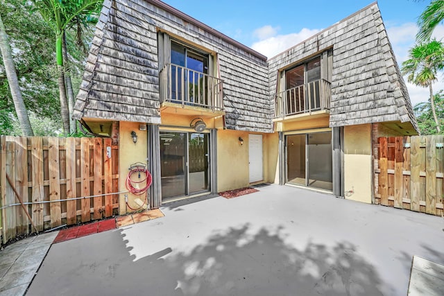 back of property with a patio and a balcony