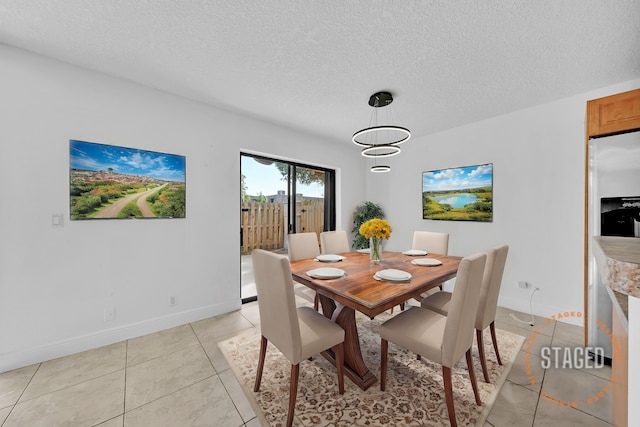 tiled dining area with a textured ceiling