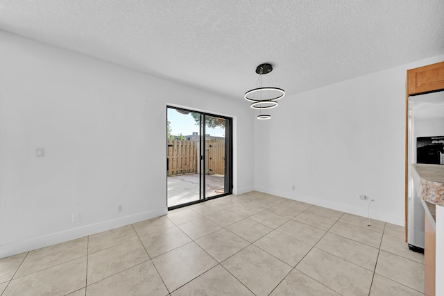 unfurnished dining area with a textured ceiling and light tile patterned floors