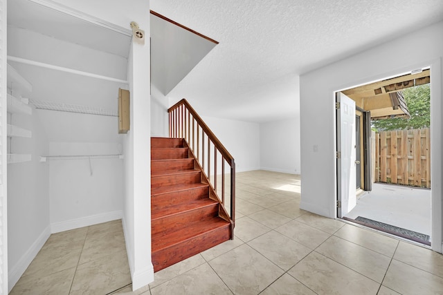 staircase featuring a textured ceiling and tile patterned floors