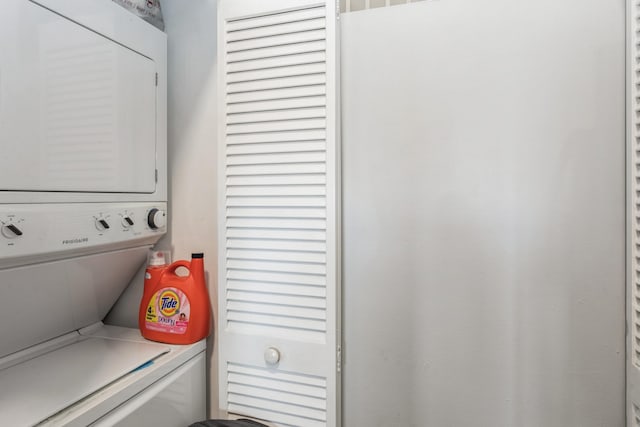 clothes washing area with stacked washer and clothes dryer