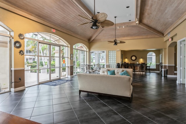 living room with ceiling fan, plenty of natural light, and wooden ceiling