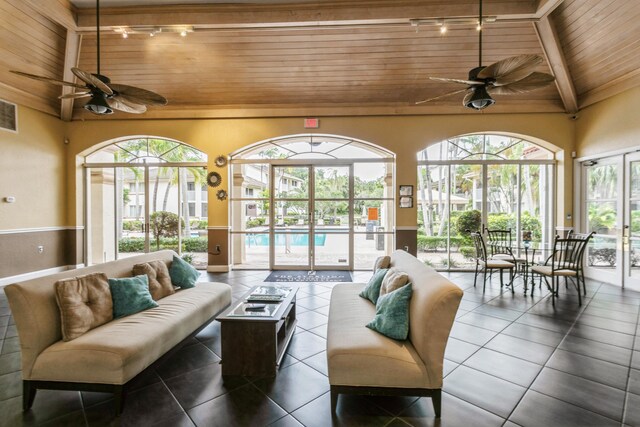 sunroom / solarium with track lighting, ceiling fan, a healthy amount of sunlight, and wood ceiling