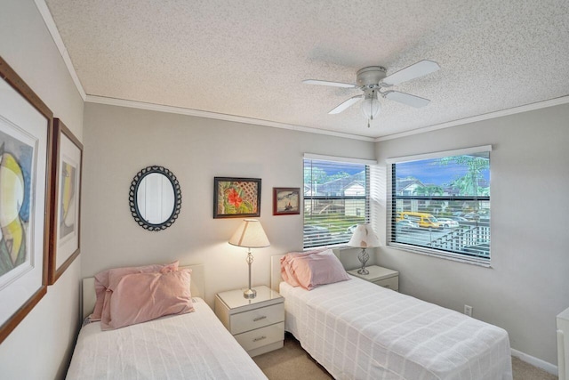 bedroom with ceiling fan, crown molding, carpet floors, and a textured ceiling