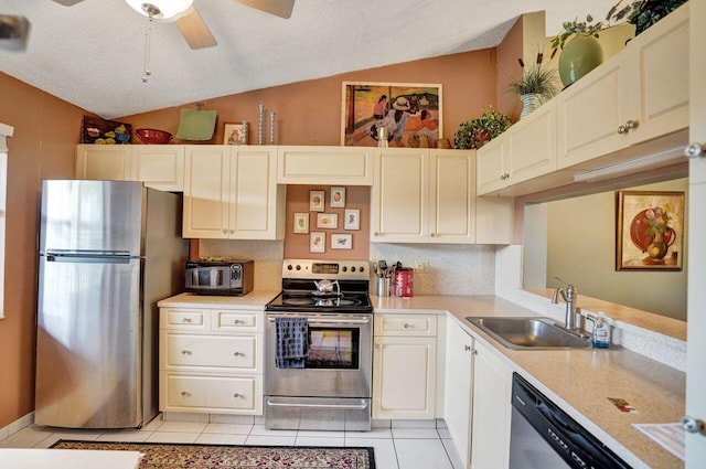 kitchen featuring appliances with stainless steel finishes, ceiling fan, sink, lofted ceiling, and light tile patterned flooring