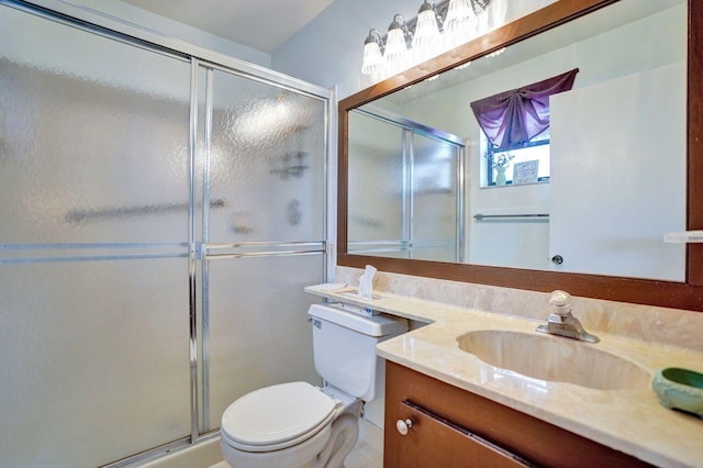 bathroom with toilet, a stall shower, and vanity