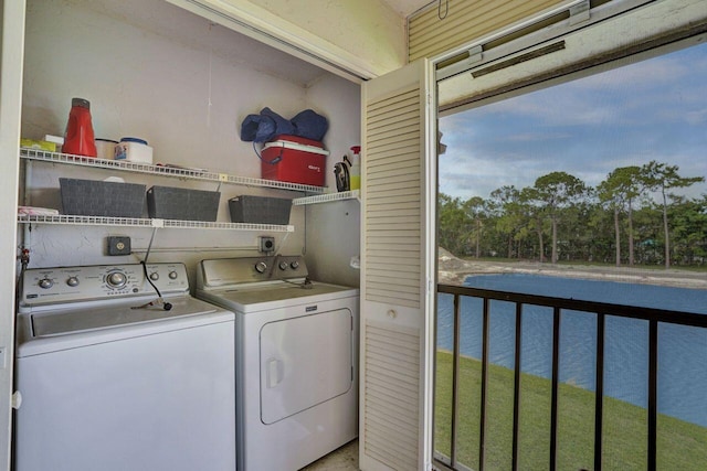 washroom with a water view and washer and clothes dryer