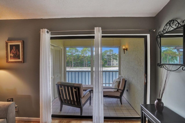 interior space with a water view, a textured ceiling, and hardwood / wood-style flooring