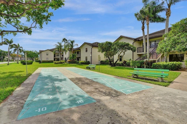 surrounding community with shuffleboard, a yard, and a residential view