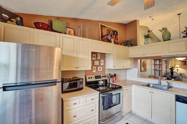 kitchen with decorative backsplash, appliances with stainless steel finishes, sink, light tile patterned floors, and lofted ceiling