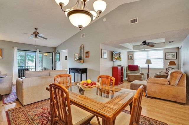 dining space with ceiling fan with notable chandelier, light wood finished floors, and visible vents