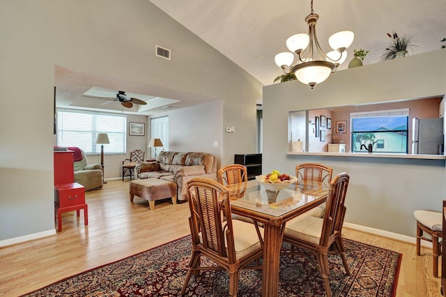 dining area with ceiling fan with notable chandelier, visible vents, baseboards, and wood finished floors