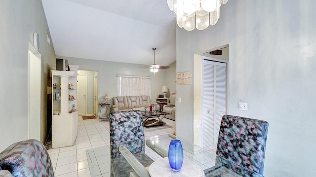 tiled dining room featuring vaulted ceiling and ceiling fan with notable chandelier