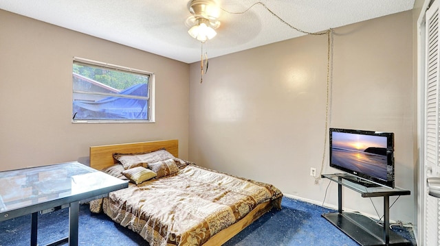 bedroom with a textured ceiling, ceiling fan, and carpet