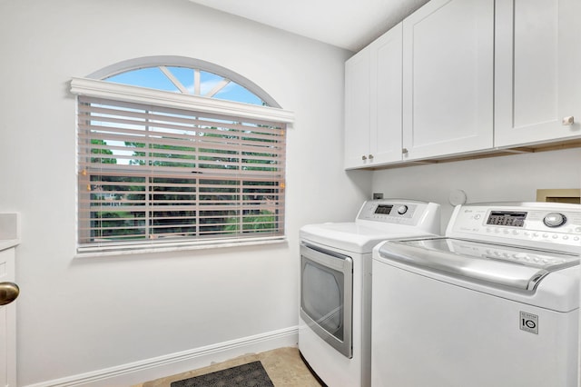 clothes washing area featuring cabinets and separate washer and dryer