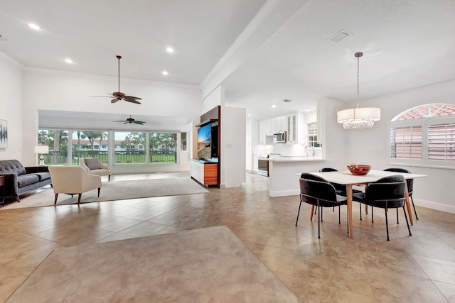 tiled dining area with crown molding and ceiling fan with notable chandelier