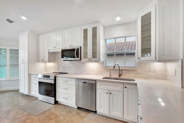 kitchen with sink, white cabinetry, a healthy amount of sunlight, and appliances with stainless steel finishes