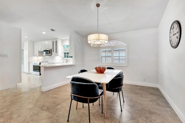 dining room with sink, plenty of natural light, and a chandelier