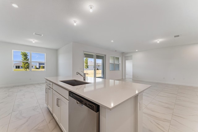 kitchen featuring stainless steel dishwasher, a healthy amount of sunlight, a center island with sink, and sink