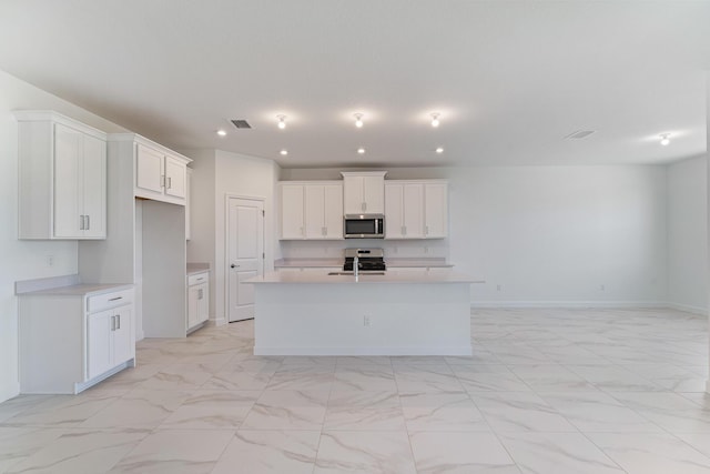 kitchen featuring a center island with sink, sink, white cabinetry, and stainless steel appliances