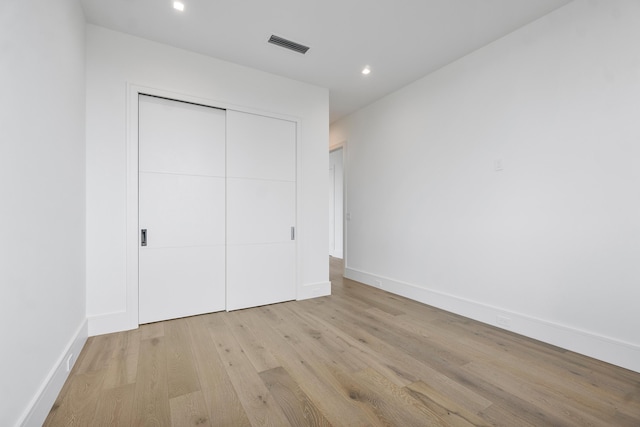 unfurnished bedroom featuring light wood-type flooring and a closet