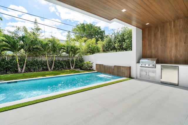 view of swimming pool featuring a patio, area for grilling, a grill, and pool water feature