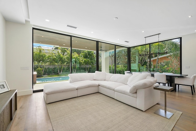 living room with light wood-type flooring, a wealth of natural light, and floor to ceiling windows