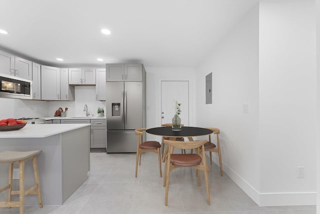 kitchen with appliances with stainless steel finishes, electric panel, sink, and gray cabinetry