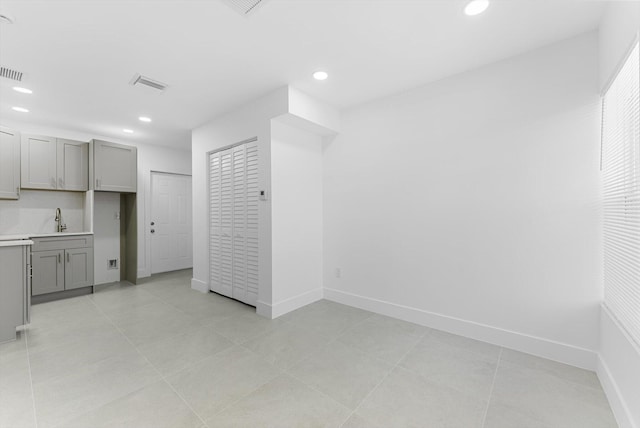 interior space featuring gray cabinets, sink, and light tile patterned floors