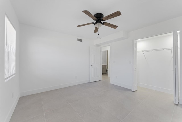 unfurnished bedroom with light tile patterned floors, ceiling fan, and a closet