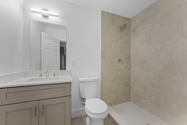 bathroom featuring vanity, toilet, and tiled shower