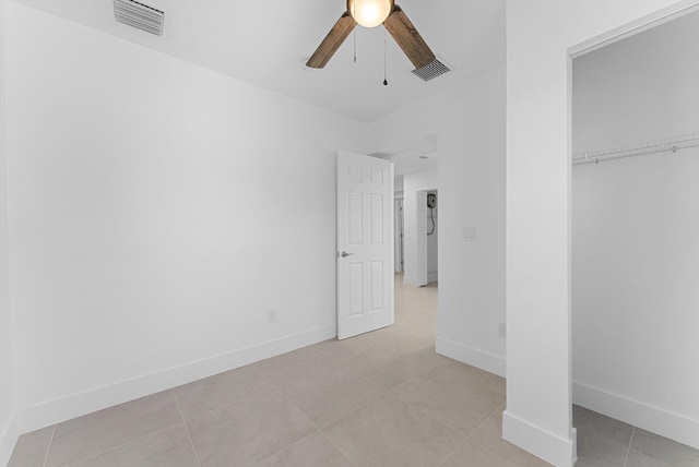 unfurnished bedroom with light tile patterned flooring, ceiling fan, and a closet