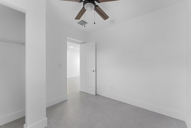 unfurnished bedroom featuring ceiling fan and a closet