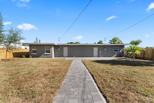 view of front of property with a front yard and cooling unit