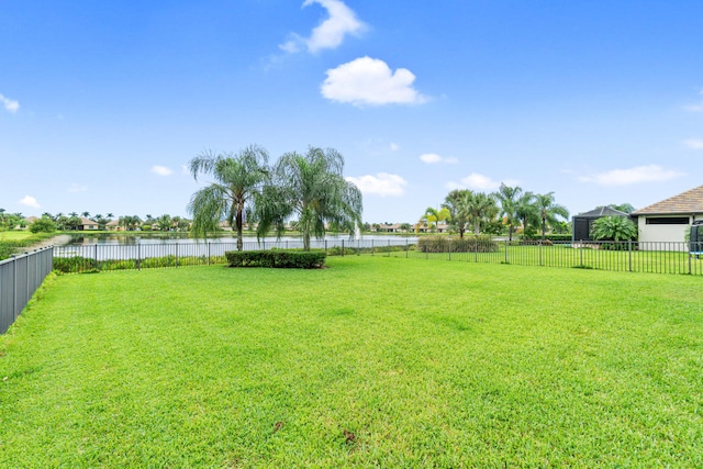 view of yard featuring a water view and fence