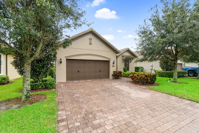 view of front facade with stucco siding, decorative driveway, a front lawn, and an attached garage