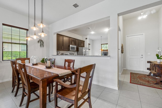 dining room featuring a wealth of natural light, visible vents, baseboards, and light tile patterned floors