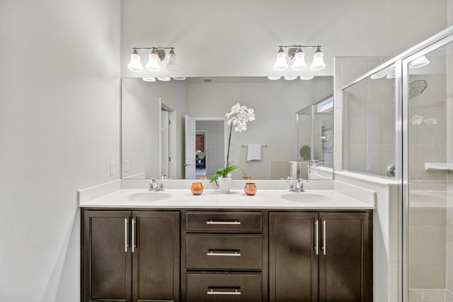 full bathroom with a shower stall, double vanity, and a sink