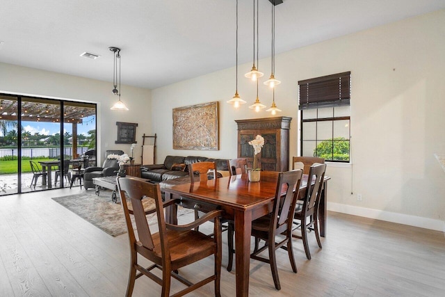 dining area with visible vents, baseboards, and wood finished floors