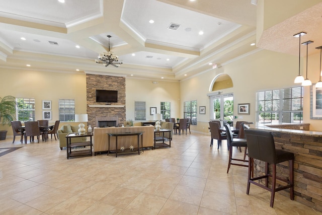 living area with light tile patterned floors, visible vents, a high ceiling, crown molding, and a notable chandelier