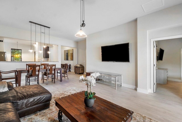 living room with visible vents, light wood-type flooring, and baseboards