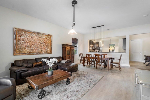 living area with light wood-style flooring and baseboards