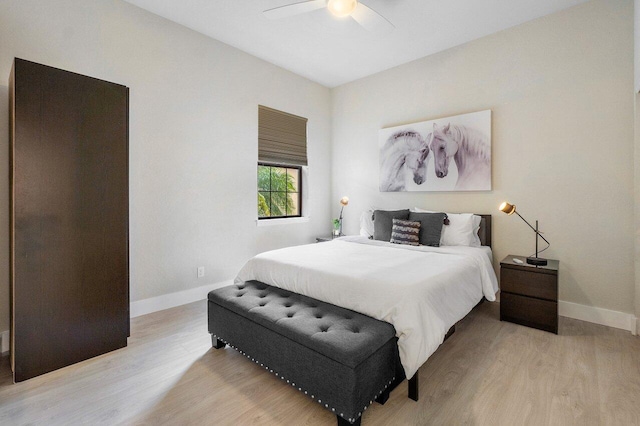 bedroom featuring a ceiling fan, light wood-style floors, and baseboards