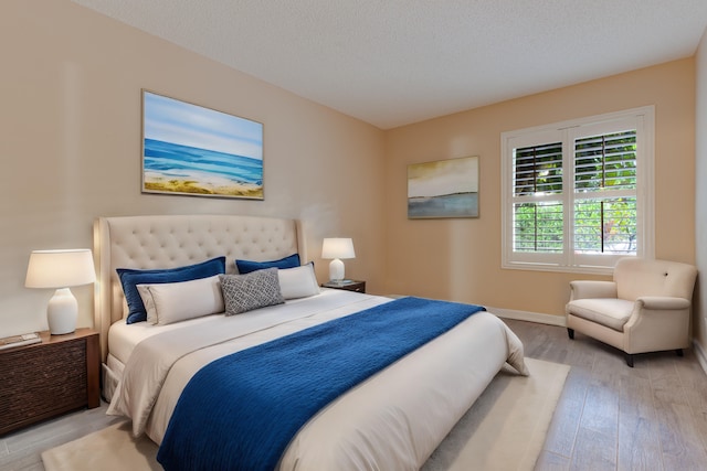 bedroom featuring light wood-type flooring and a textured ceiling