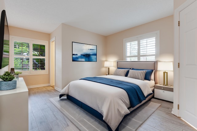 bedroom featuring a textured ceiling and light hardwood / wood-style floors