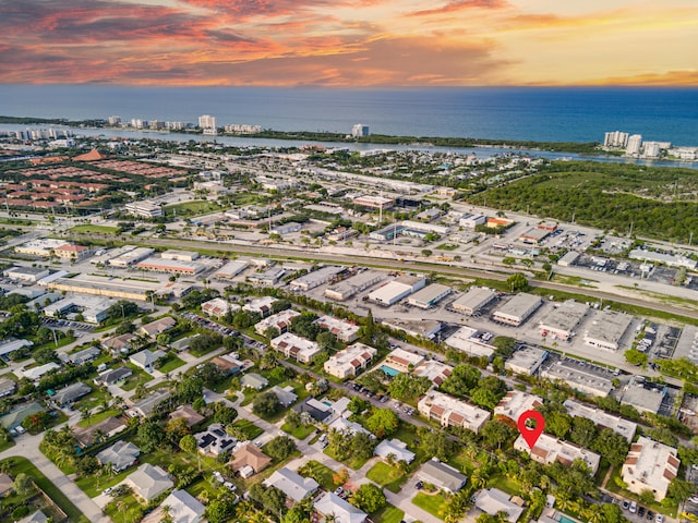 aerial view at dusk featuring a water view