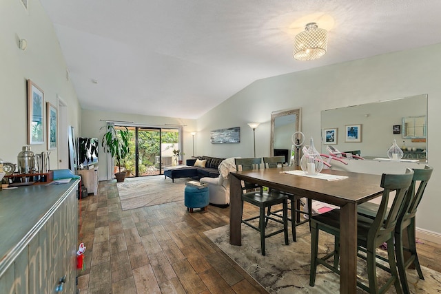 dining room featuring dark wood-type flooring and vaulted ceiling