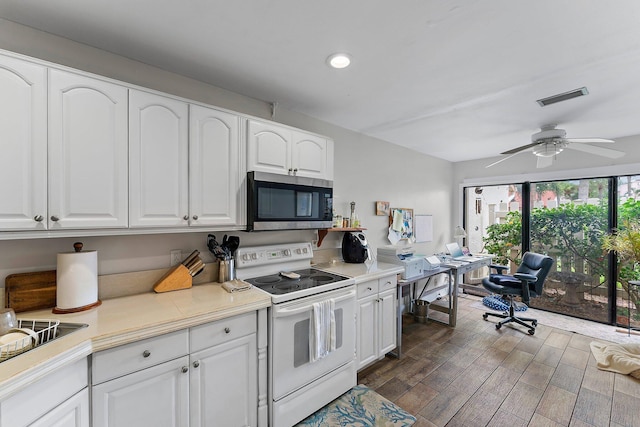 kitchen featuring dark hardwood / wood-style floors, white cabinetry, and electric stove