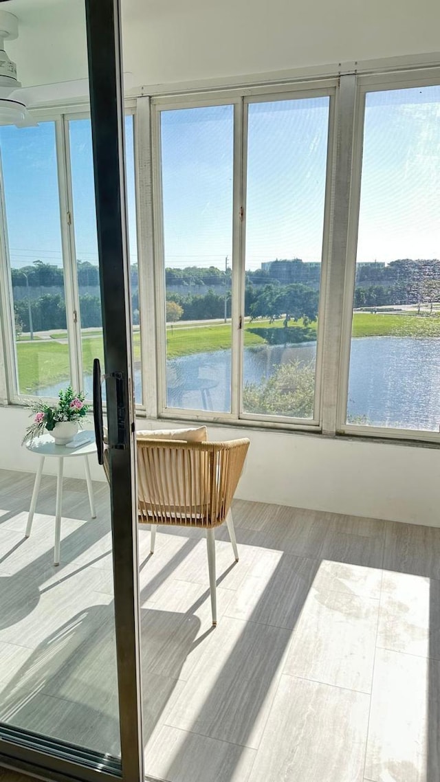 sunroom / solarium with a water view and a wealth of natural light