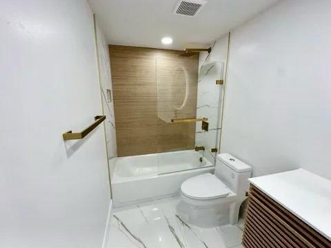 bathroom featuring tiled shower / bath combo and toilet